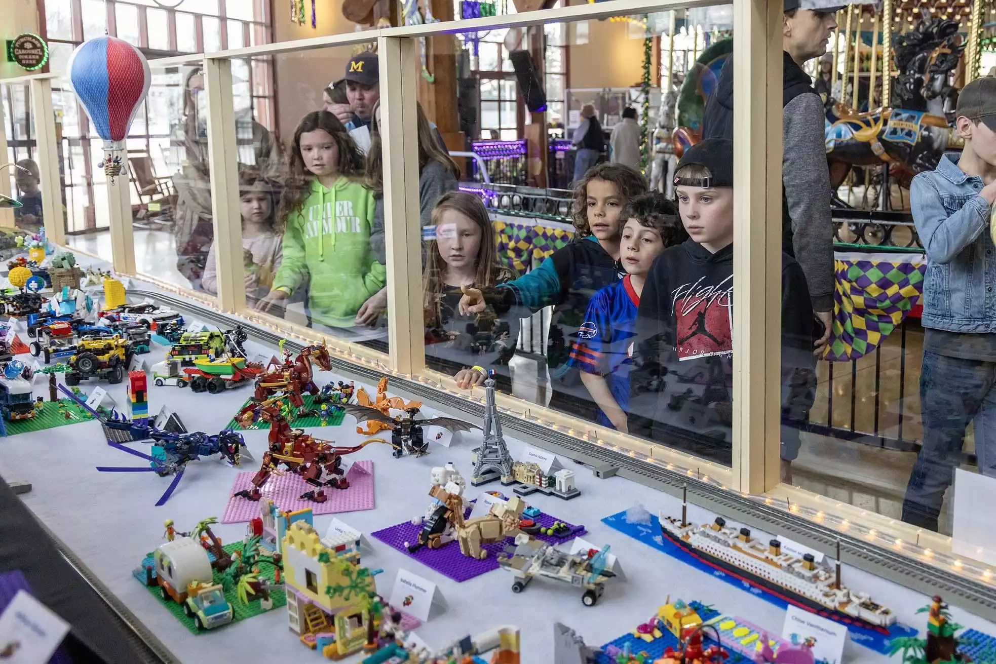 People enjoying looking at a display of Lego builds.