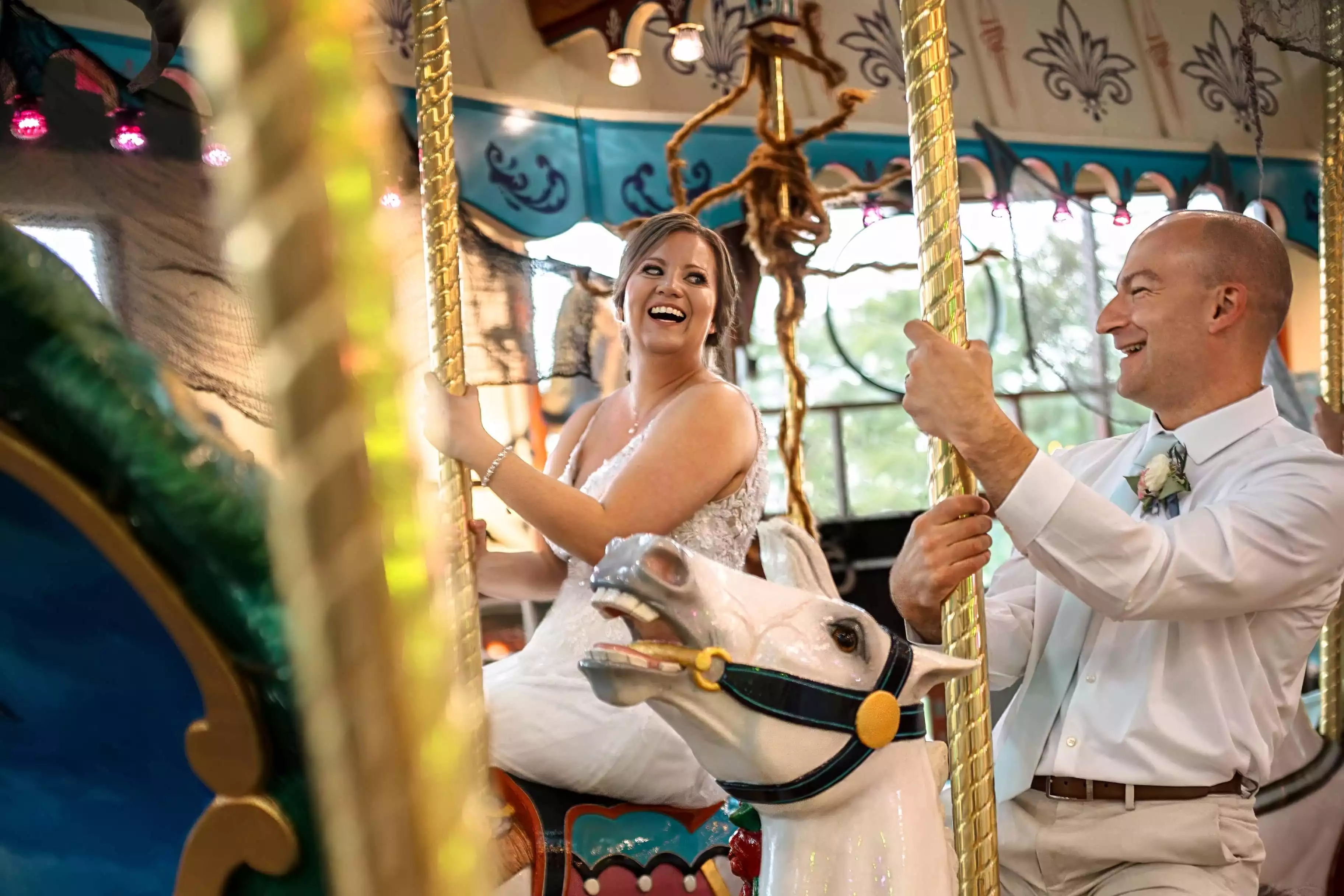 Bride and groom riding the carousel.