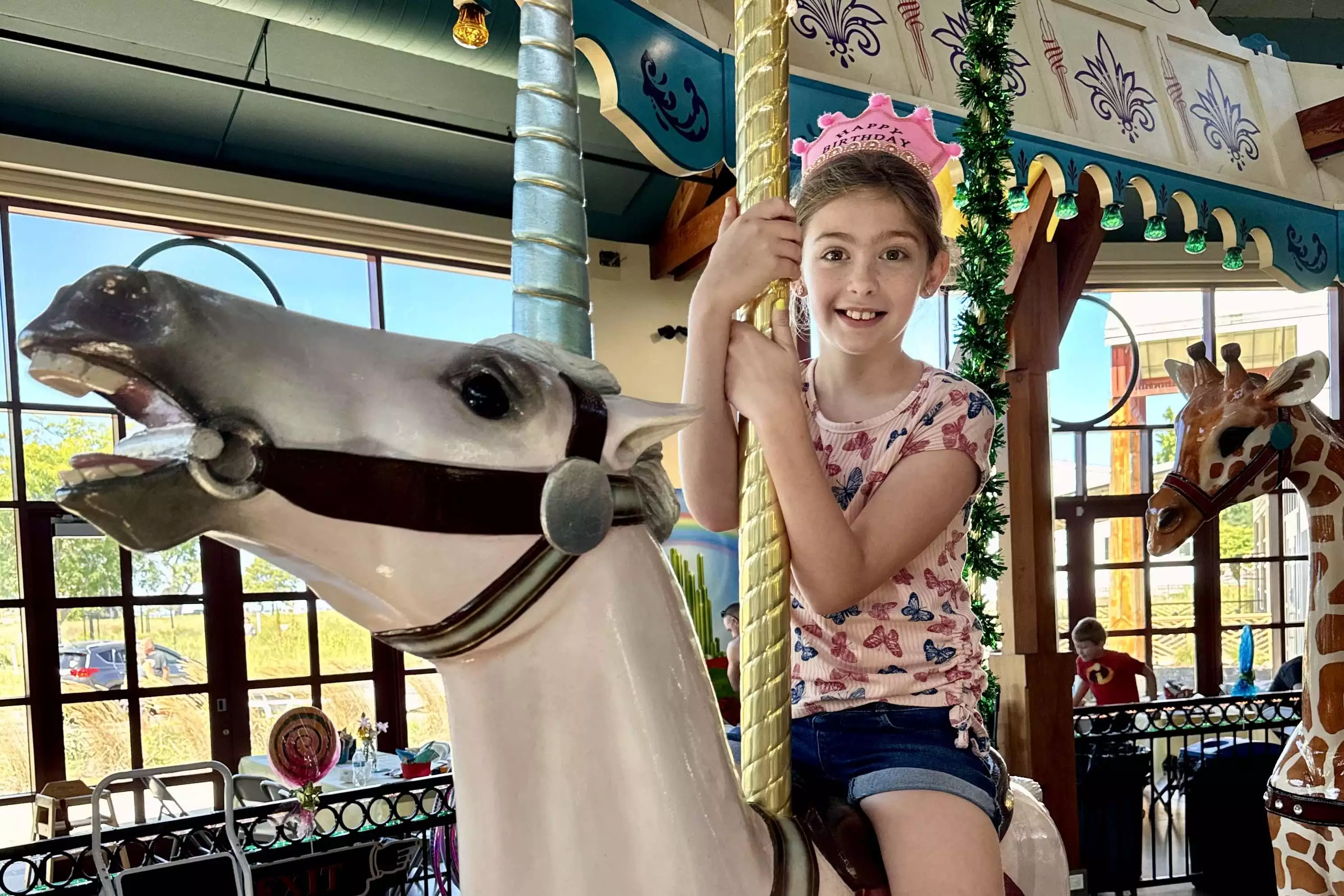 A child riding on the unicorn carousel figure.